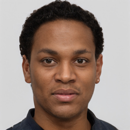 Joyful black young-adult male with short  black hair and brown eyes