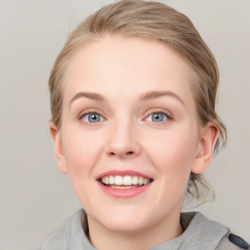 Joyful white young-adult female with medium  brown hair and blue eyes