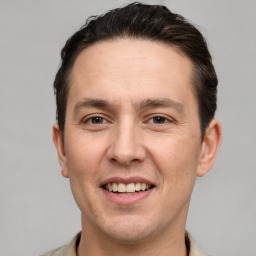 Joyful white adult male with short  brown hair and brown eyes