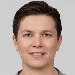 Joyful white young-adult male with short  brown hair and grey eyes