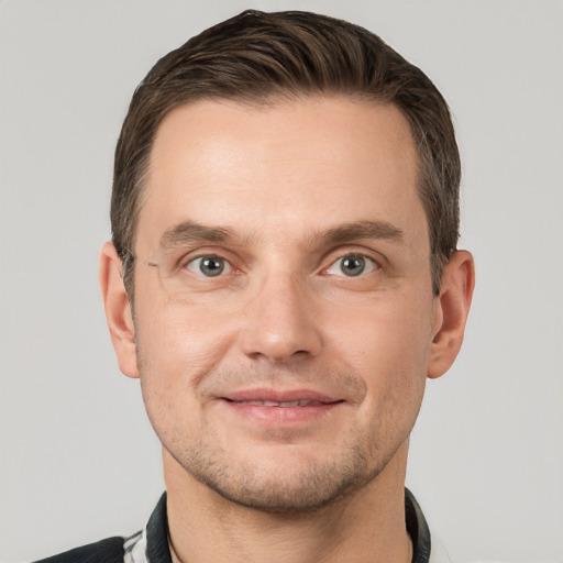 Joyful white young-adult male with short  brown hair and grey eyes