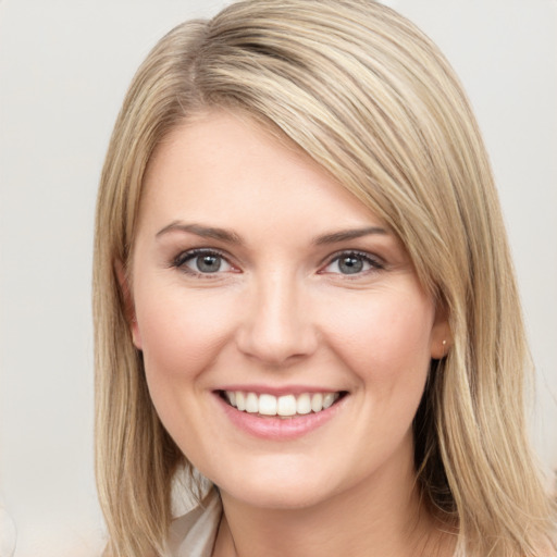 Joyful white young-adult female with medium  brown hair and grey eyes