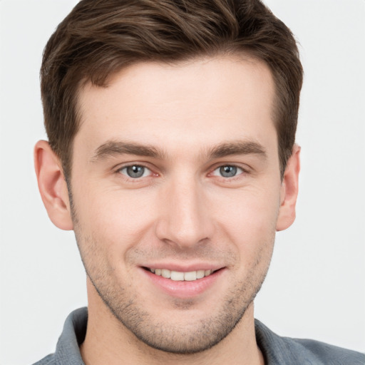 Joyful white young-adult male with short  brown hair and grey eyes