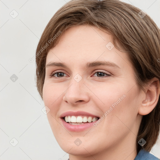 Joyful white young-adult female with medium  brown hair and blue eyes