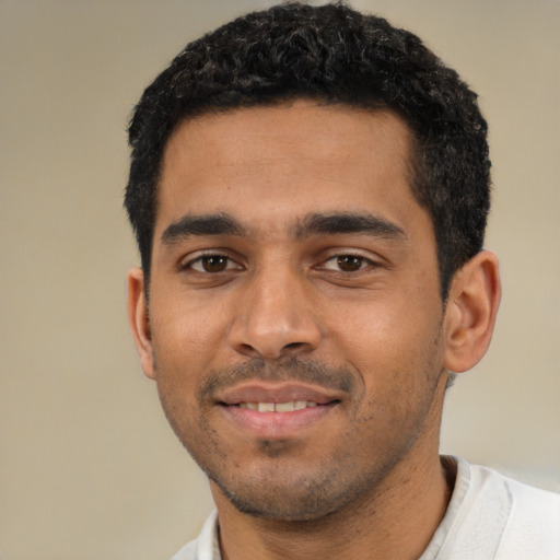 Joyful latino young-adult male with short  black hair and brown eyes