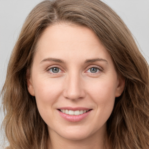 Joyful white young-adult female with long  brown hair and green eyes