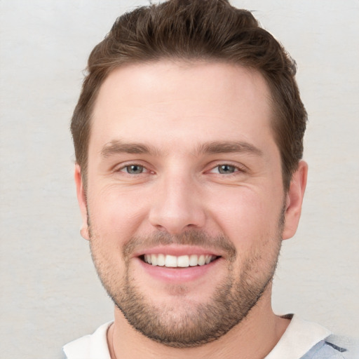 Joyful white young-adult male with short  brown hair and grey eyes