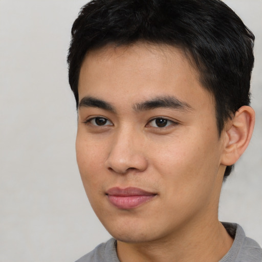 Joyful asian young-adult male with short  black hair and brown eyes