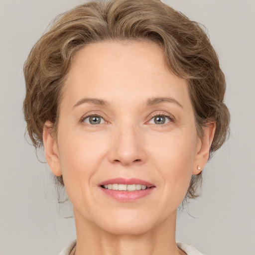 Joyful white adult female with medium  brown hair and grey eyes