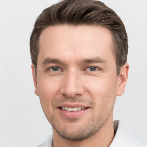 Joyful white young-adult male with short  brown hair and grey eyes