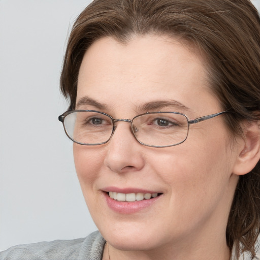 Joyful white adult female with medium  brown hair and grey eyes