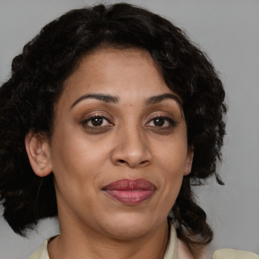 Joyful black adult female with medium  brown hair and brown eyes