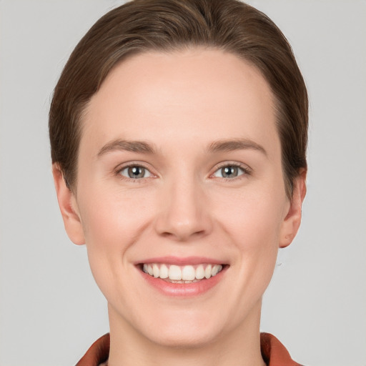 Joyful white young-adult female with short  brown hair and grey eyes