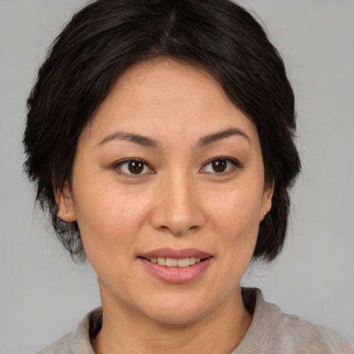 Joyful asian adult female with medium  brown hair and brown eyes