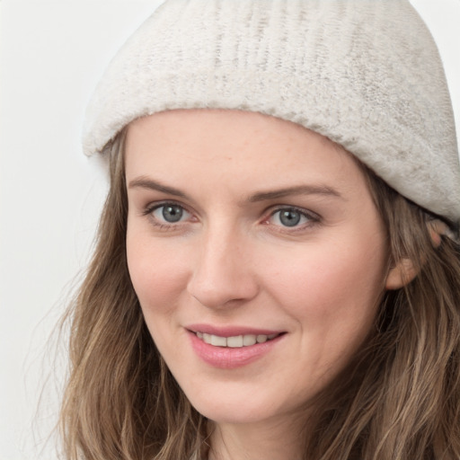 Joyful white young-adult female with long  brown hair and blue eyes