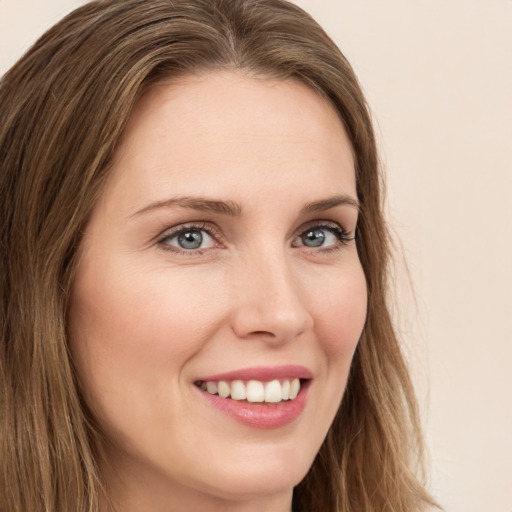 Joyful white young-adult female with long  brown hair and green eyes