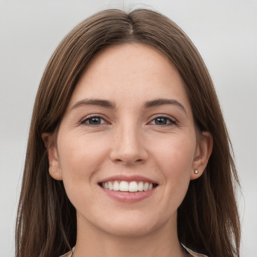 Joyful white young-adult female with long  brown hair and grey eyes