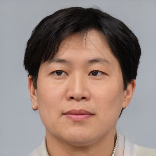 Joyful asian adult male with short  brown hair and brown eyes