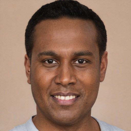 Joyful black young-adult male with short  black hair and brown eyes