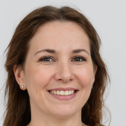 Joyful white young-adult female with long  brown hair and grey eyes