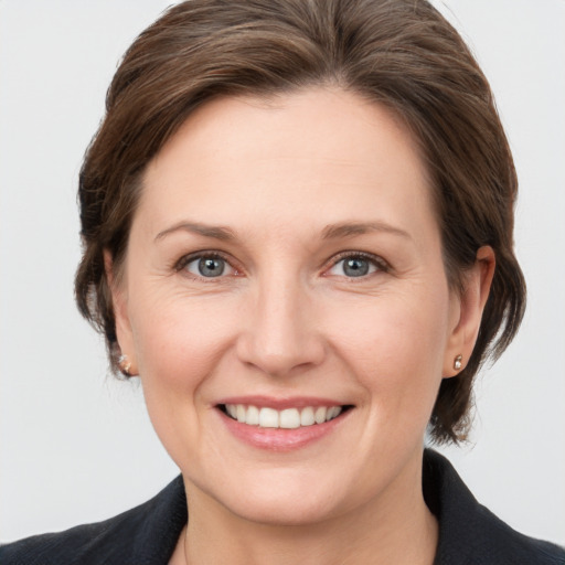 Joyful white adult female with medium  brown hair and grey eyes