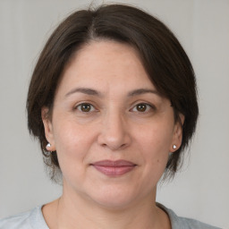 Joyful white adult female with medium  brown hair and brown eyes