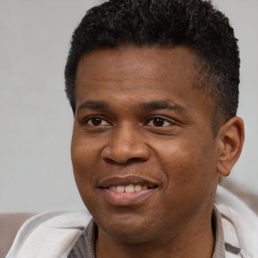 Joyful black young-adult male with short  black hair and brown eyes