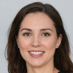 Joyful white young-adult female with long  brown hair and green eyes