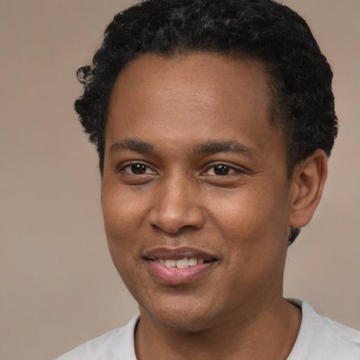Joyful black young-adult male with short  black hair and brown eyes