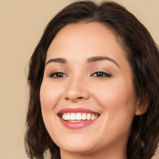 Joyful white young-adult female with long  brown hair and brown eyes