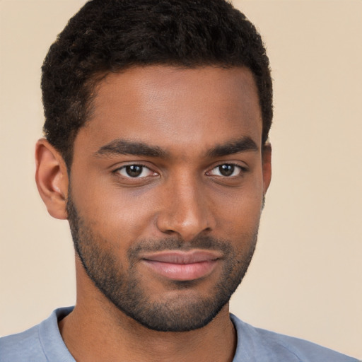 Joyful black young-adult male with short  brown hair and brown eyes