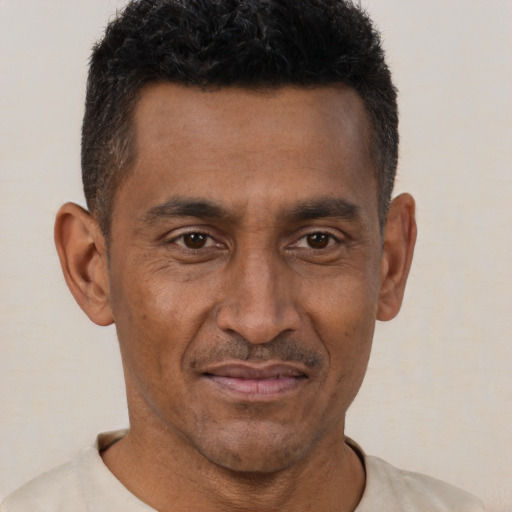 Joyful black young-adult male with short  brown hair and brown eyes