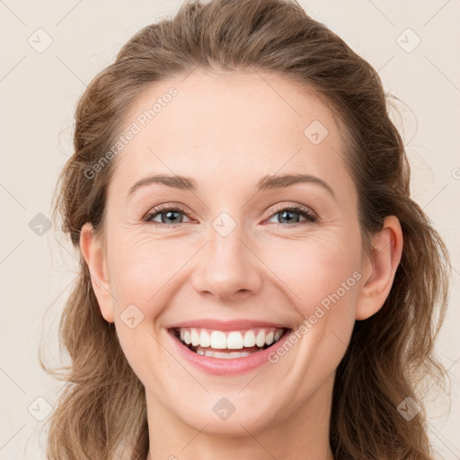 Joyful white young-adult female with long  brown hair and green eyes