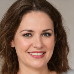 Joyful white young-adult female with medium  brown hair and green eyes