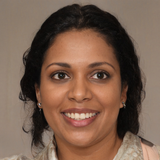 Joyful black young-adult female with medium  brown hair and brown eyes