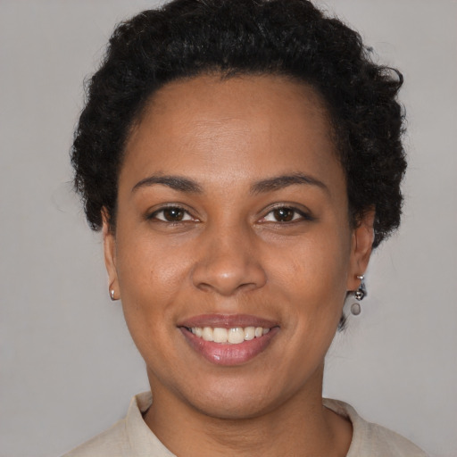Joyful black young-adult female with short  brown hair and brown eyes