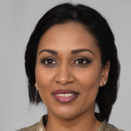 Joyful black adult female with medium  brown hair and brown eyes