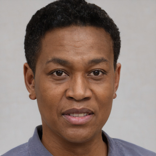 Joyful black adult male with short  black hair and brown eyes