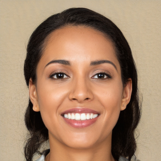 Joyful latino young-adult female with medium  black hair and brown eyes