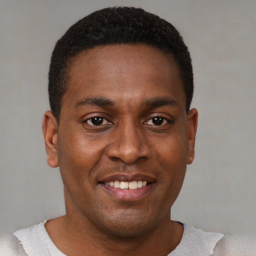 Joyful black young-adult male with short  brown hair and brown eyes