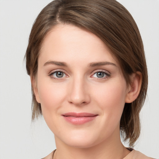 Joyful white young-adult female with medium  brown hair and grey eyes