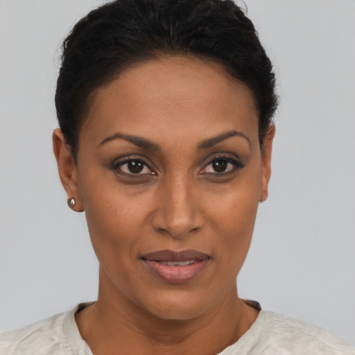 Joyful black young-adult female with short  brown hair and brown eyes