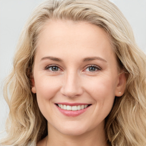 Joyful white young-adult female with long  brown hair and blue eyes