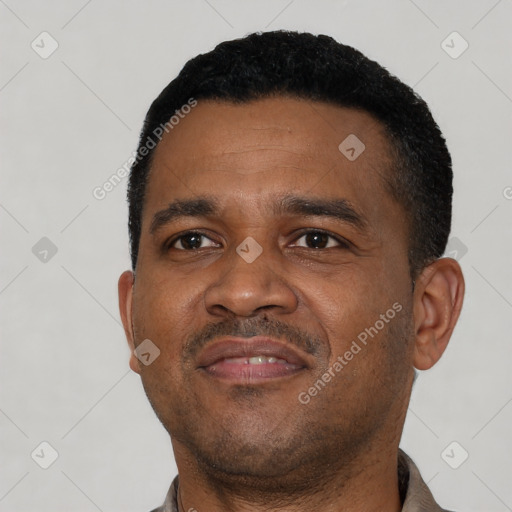 Joyful black young-adult male with short  black hair and brown eyes