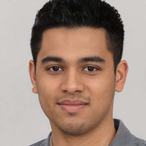Joyful latino young-adult male with short  black hair and brown eyes