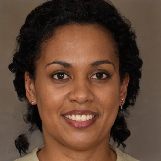 Joyful black adult female with medium  brown hair and brown eyes