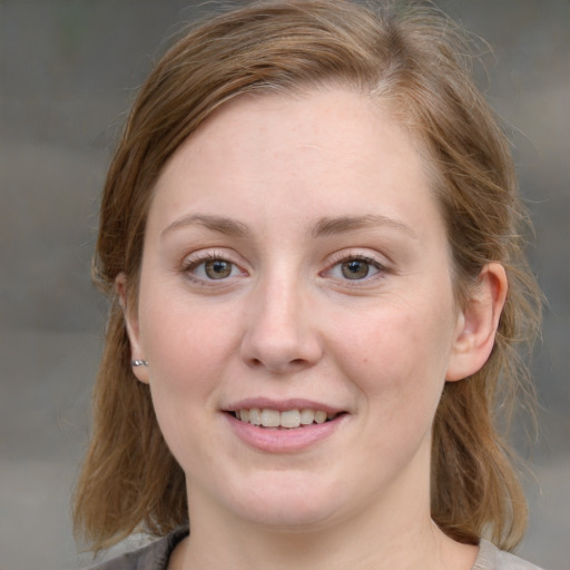 Joyful white young-adult female with medium  brown hair and blue eyes