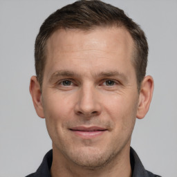 Joyful white adult male with short  brown hair and grey eyes