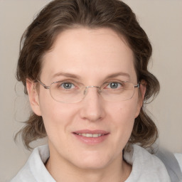 Joyful white adult female with medium  brown hair and blue eyes