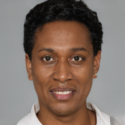 Joyful black young-adult female with short  black hair and brown eyes